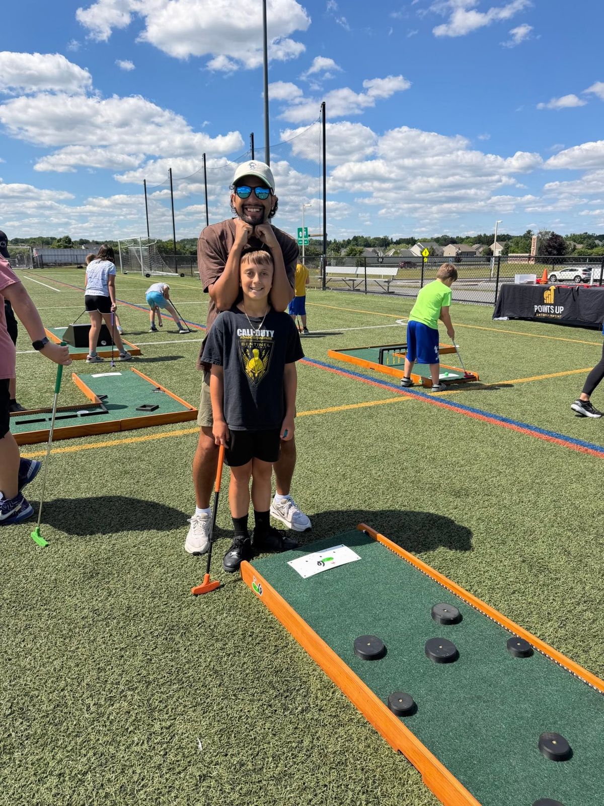 Our crew with a young golfer at a Points Up mobile mini golf event